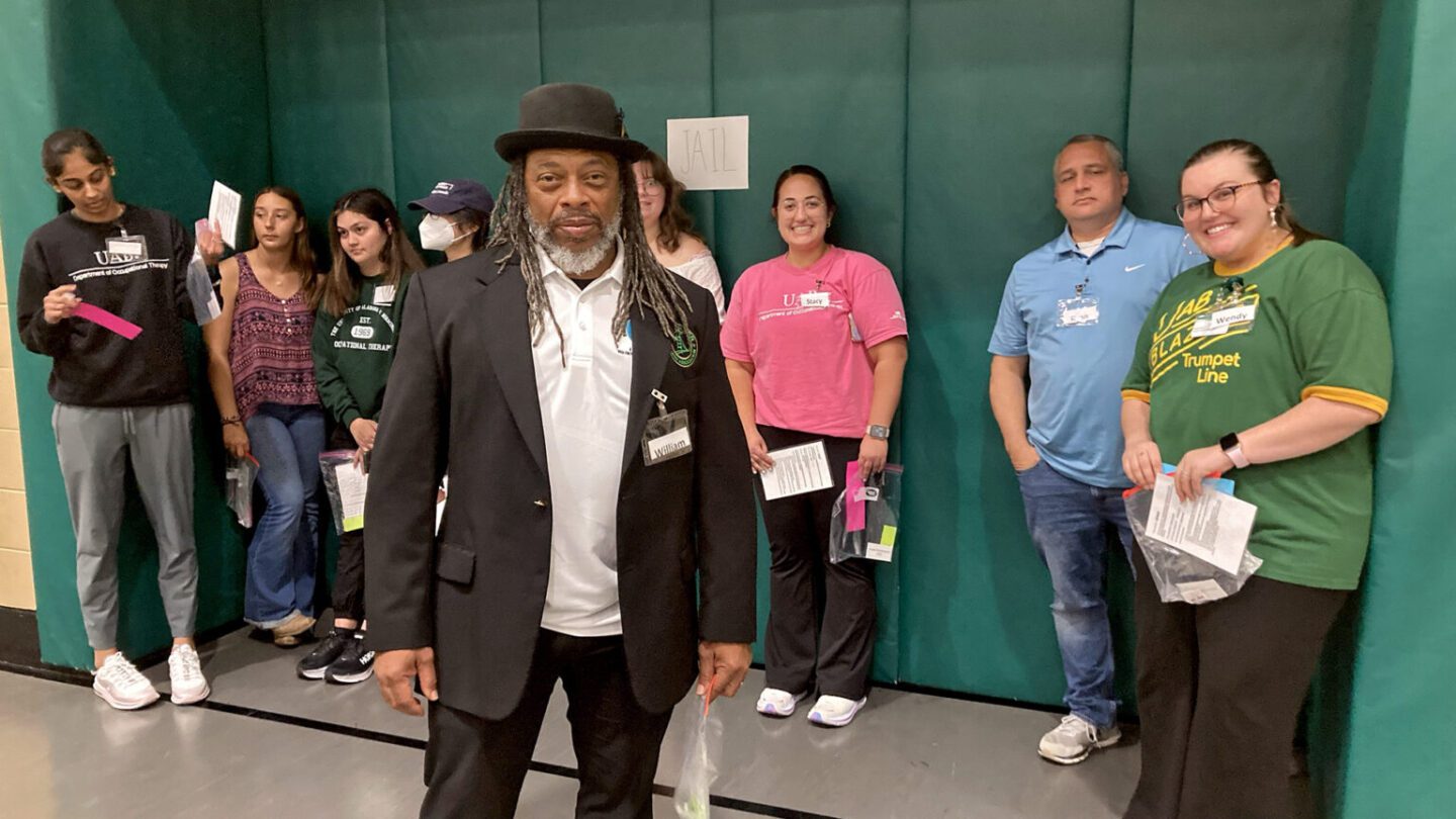 Tim Lanier stands in front of the makeshift jail, which he patrolled during the reentry simulation activity at UAB’s recreation center, on March 24, 2023. (Mary Scott Hodgin/WBHM)